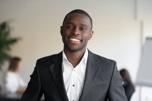 Head shot portrait attractive African ethnicity businessman wearing formal elegant suit white shirt posing looking at camera. Head of sales department, representative of successful team member concept